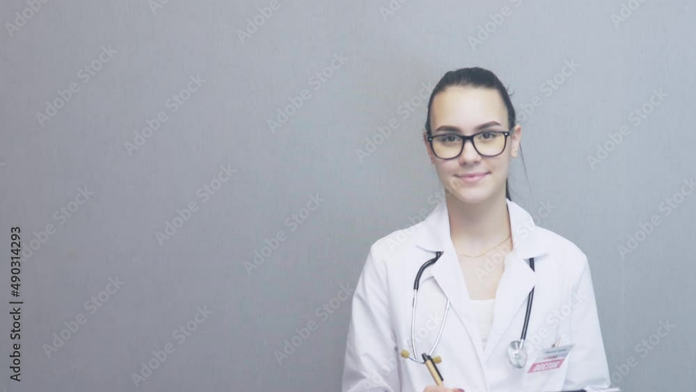 portrait young female doctor in white uniform with stethoscope smiling to camera, copy space on grey background. caucasian pretty woman professional medical physician in lab coat. health care concept portrait young female doctor in white uniform with stethoscope smiling to camera, copy space on grey background. caucasian pretty woman professional medical physician in lab coat. health care concept