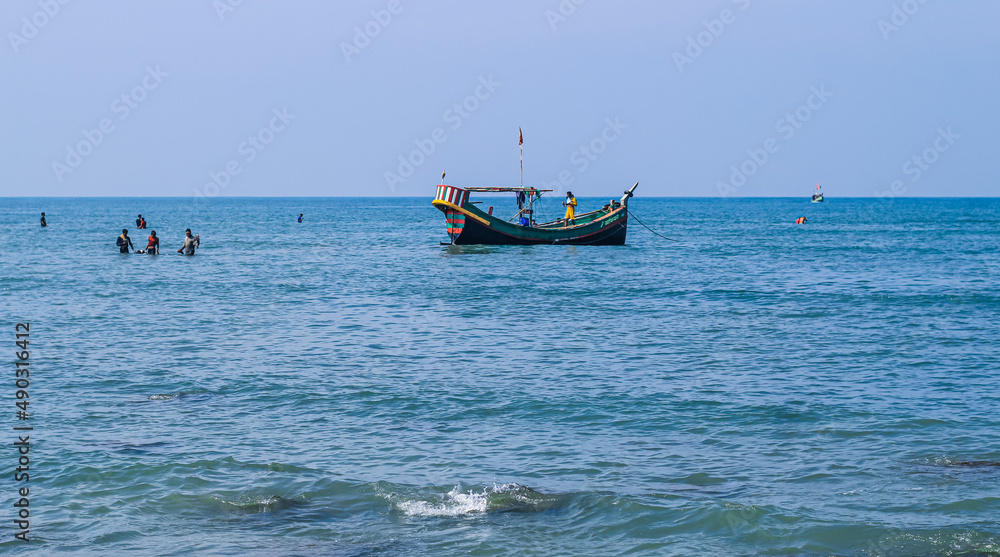 Photo of Industrial fishing boat. Fishing boat in the sea. The fishing industry in India. Indian traditional fishing boat. Photo of Industrial fishing boat. Fishing boat in the sea. The fishing industry in India. Indian traditional fishing boat.