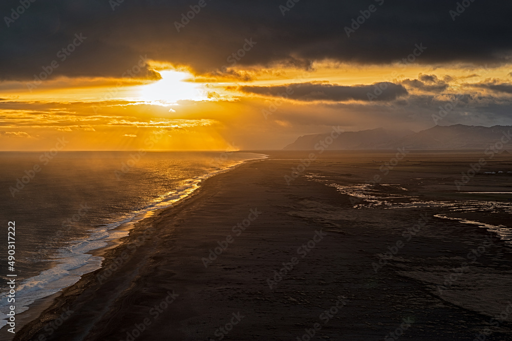 View of the black sand beach from Dyrholaey promontory on Atlantic South Coast at sunset, Iceland