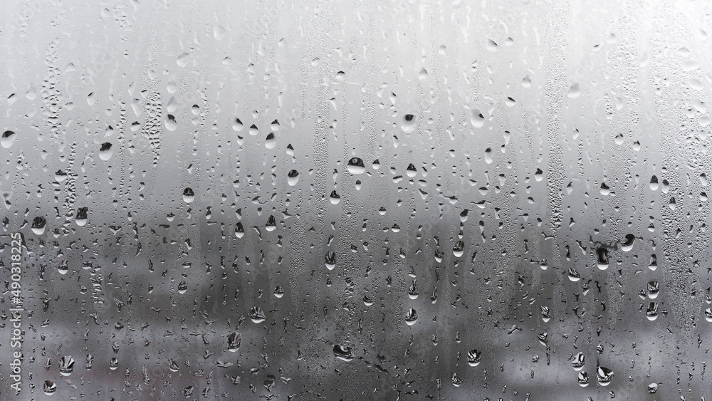 Steamy window with water drops on surface of shower cabin as background blurred Image Steamy window with water drops on surface of shower cabin as background blurred Image