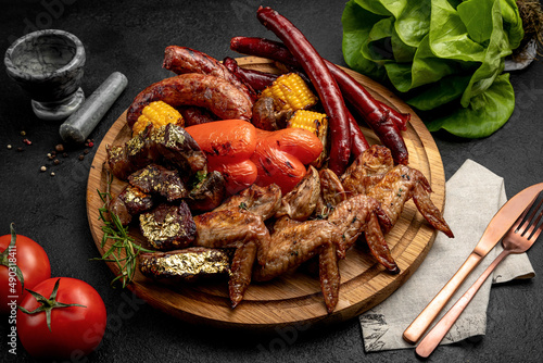 a tray of various grilled products. grilled steak, grilled sausages, grilled vegetables. assorted meat