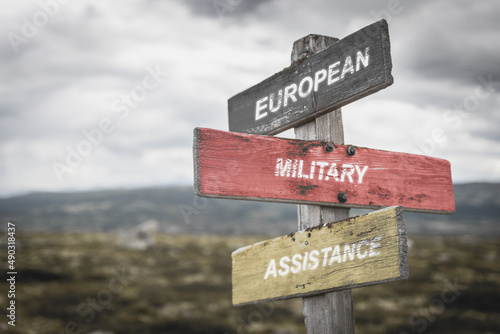 european military assistance text quote on german flag painted on wooden signpost outdoors in nature. To simulate the conflict in ukraine, europe.
