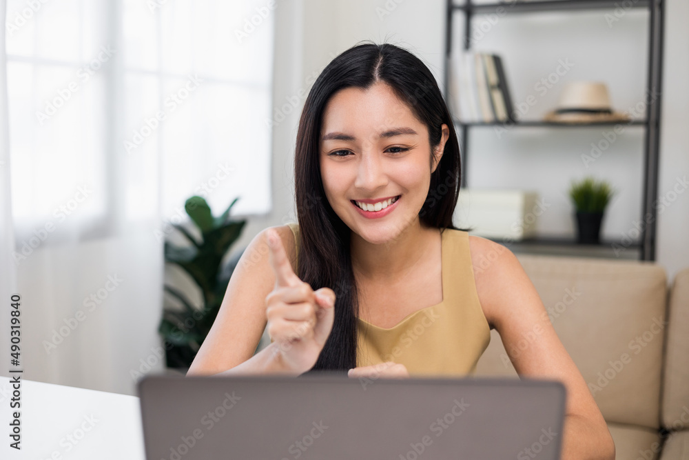 Asian Woman looking at screen Meeting on social media. Beautiful asian woman using laptop chatting video conference online sitting in living room at home. Work from home. Asian Woman looking at screen Meeting on social media. Beautiful asian woman using laptop chatting video conference online sitting in living room at home. Work from home.