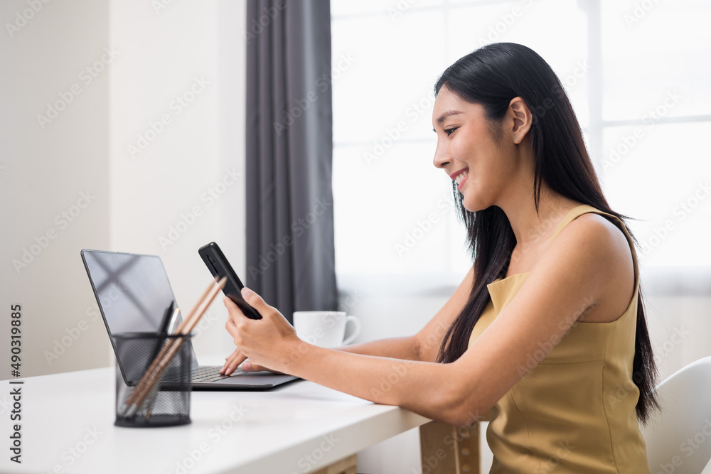 Young asian woman using smartphone chatting video conference online sitting in living room at home. Business Woman shopping online by smartphone. Young asian woman using smartphone chatting video conference online sitting in living room at home. Business Woman shopping online by smartphone.