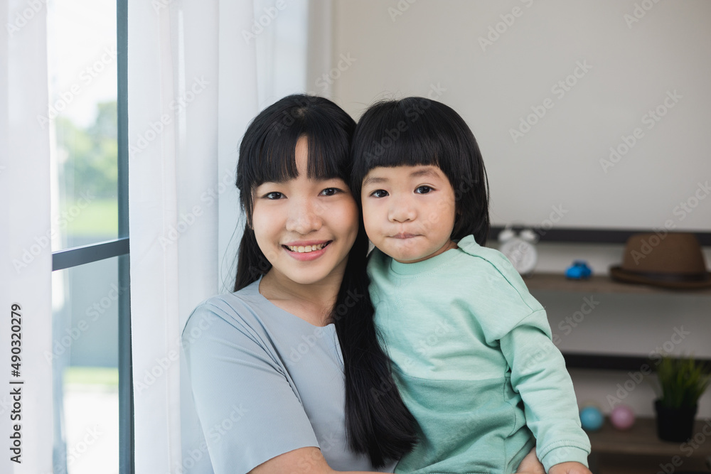 Mom carry son looking at camera feeling happy in the house. Mother holding little boy walking around living room at home happy family moment smiling to camera. Mom carry son looking at camera feeling happy in the house. Mother holding little boy walking around living room at home happy family moment smiling to camera.