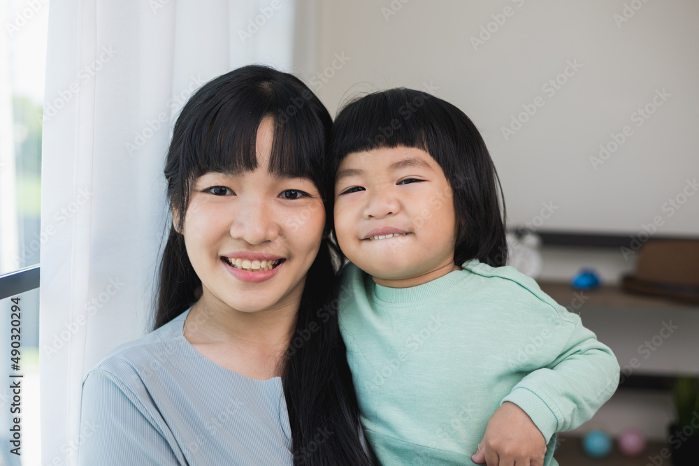 Mom carry son looking at camera feeling happy in the house. Mother holding little boy walking around living room at home happy family moment smiling to camera. Mom carry son looking at camera feeling happy in the house. Mother holding little boy walking around living room at home happy family moment smiling to camera.