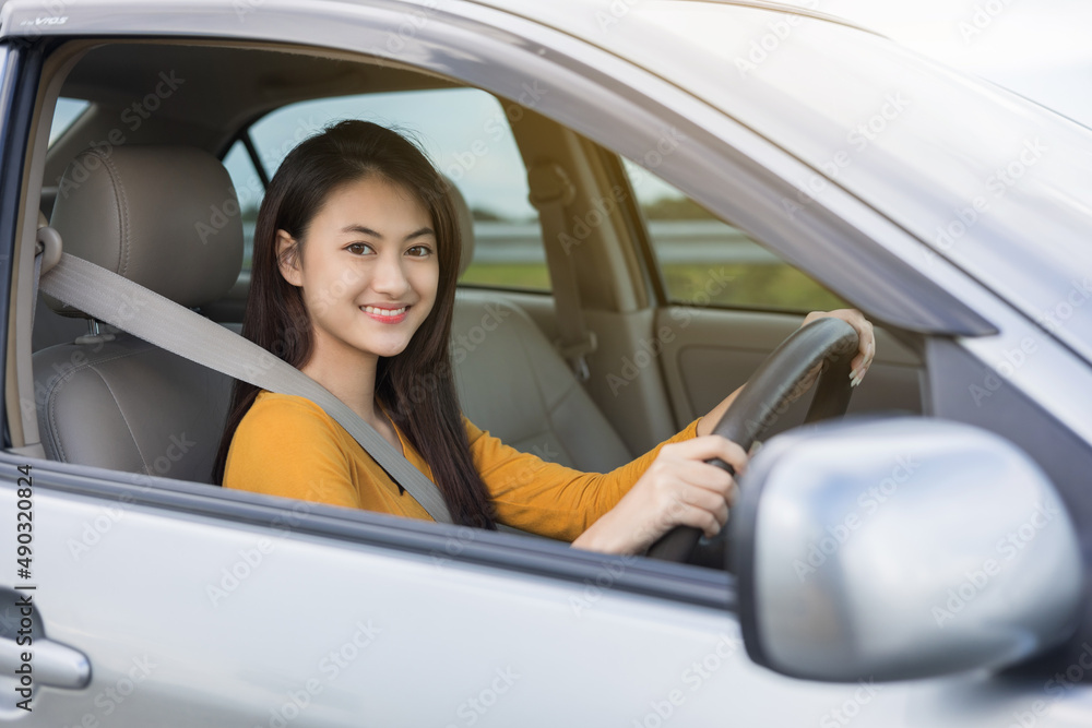Young beautiful asian women getting new car. she very happy and excited looking outside window. Smiling female driving vehicle on the road on a bright day Young beautiful asian women getting new car. she very happy and excited looking outside window. Smiling female driving vehicle on the road on a bright day