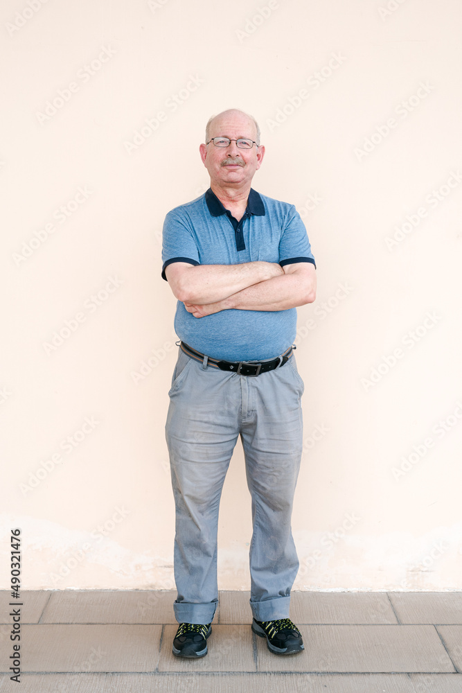 Full length portrait of happy senior man looking at camera Full length portrait of happy senior man looking at camera