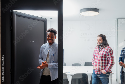 multiracial group of office workers leaving a meeting room. people at work.