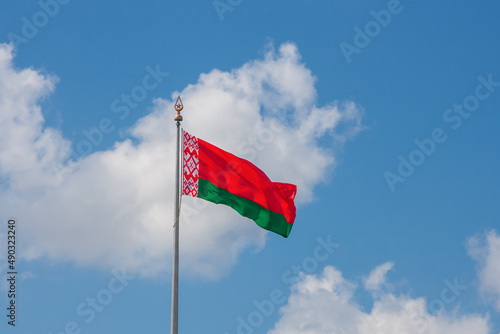 Flag of the Republic of Belarus on a background of blue sky and clouds