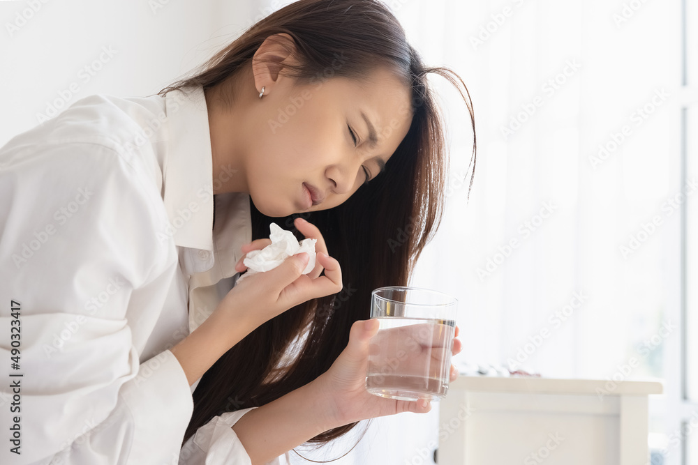 Asian woman feeling sick have a headache, coughing because of Coronavirus Covid-19. Protection and recovery from the illness quarantine at home, Stay at home. Asian woman feeling sick have a headache, coughing because of Coronavirus Covid-19. Protection and recovery from the illness quarantine at home, Stay at home.