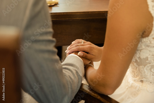 verliebtes Brautpaar während der standesamtlichen Trauung hält Händchn