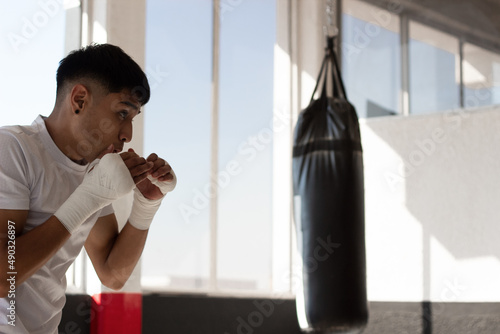 young Latino boxer training with discipline and determination, in his face you can see his concentration and that he has clear goals. photo