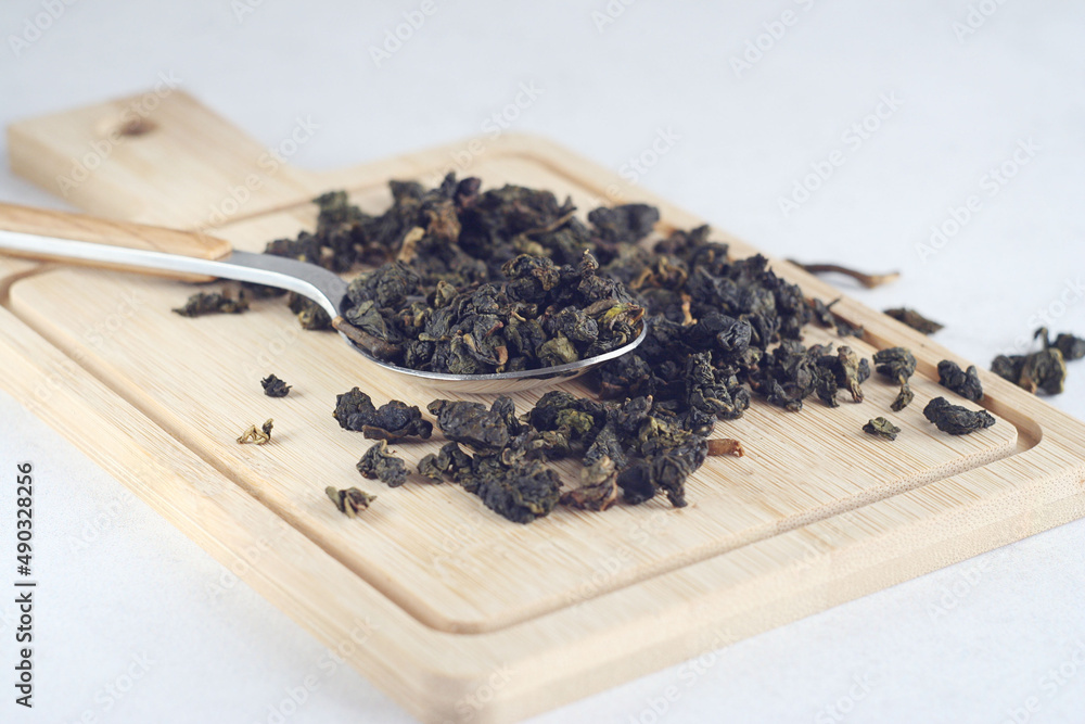 Green tea leaves lie on a wooden bamboo board. Rest Green tea leaves lie on a wooden bamboo board. Rest
