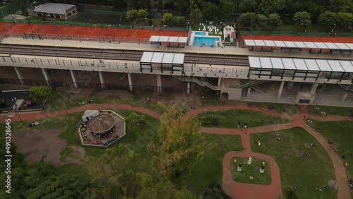 Railway station between Barrancas playground and tennis club of neighborhood Belgrano, Buenos Aires in Argentina. Aerial top-down orbiting photo