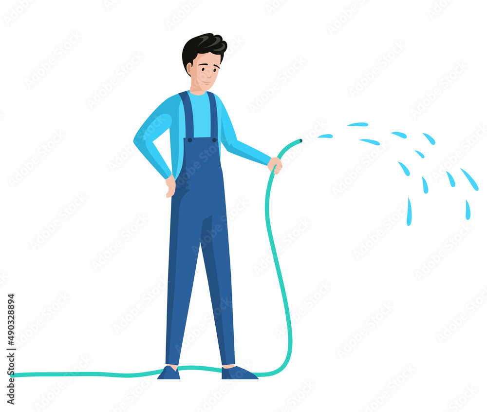 Young man sprinkling with water from hose isolated on white background. Gardener or worker in jumpsuit with hosepipe. Guy cares for garden. Male character holding garden hose to water plant