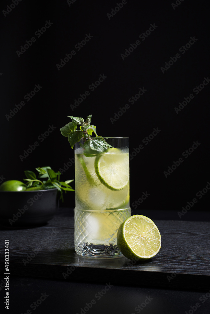 Un vaso de ginebra y tónica con rodajas de lima y hielo sobre fondo negro Un vaso de ginebra y tónica con rodajas de lima y hielo sobre fondo negro