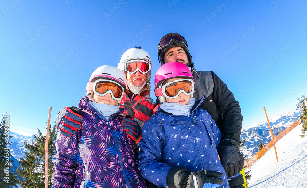 Family enjoying winter vacations taking selfie in skiing gear. Family enjoying winter vacations taking selfie in skiing gear.