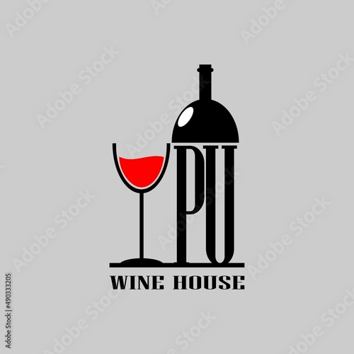 PU letter on wine bottle next to a glass of wine