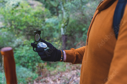 Fotografia Chico con barbar muy alto con brujula en un bosque y equipamiento de senderismo