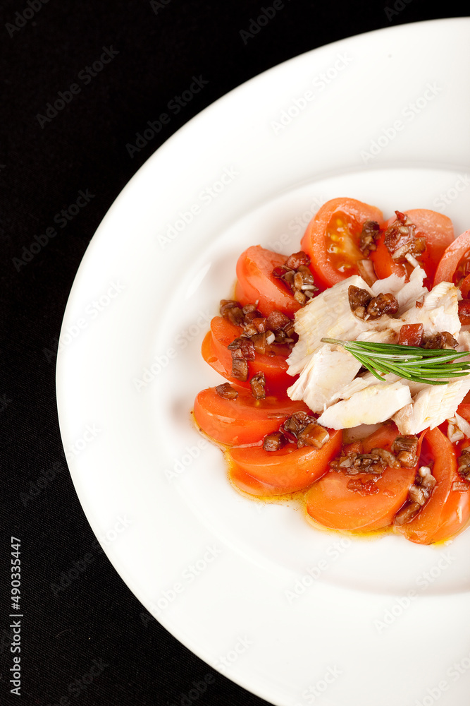 Ensalada de tomates con atún en plato redondo