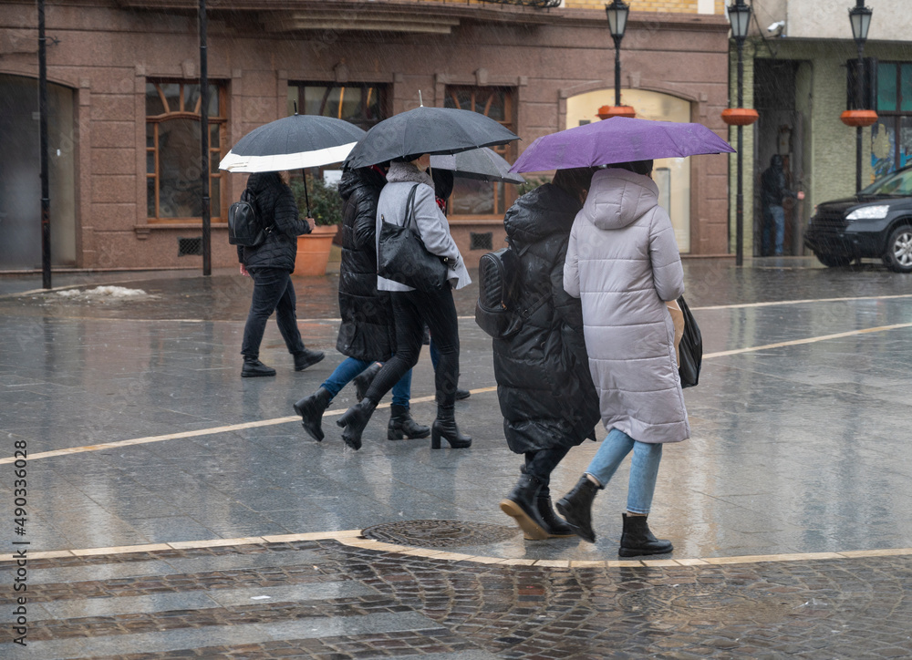 Obraz premium People with umbrella on the street of the city on a rainy day