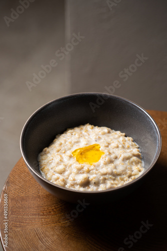 Healthy breakfast oatmeal porridge in bowl. Warm porridge oats, vegan vegetarian weight loss dieting breakfast food