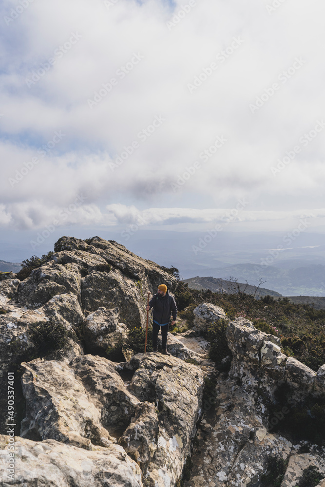Chico con barba y ropa de abrigo en la cima de una montaña Chico con barba y ropa de abrigo en la cima de una montaña