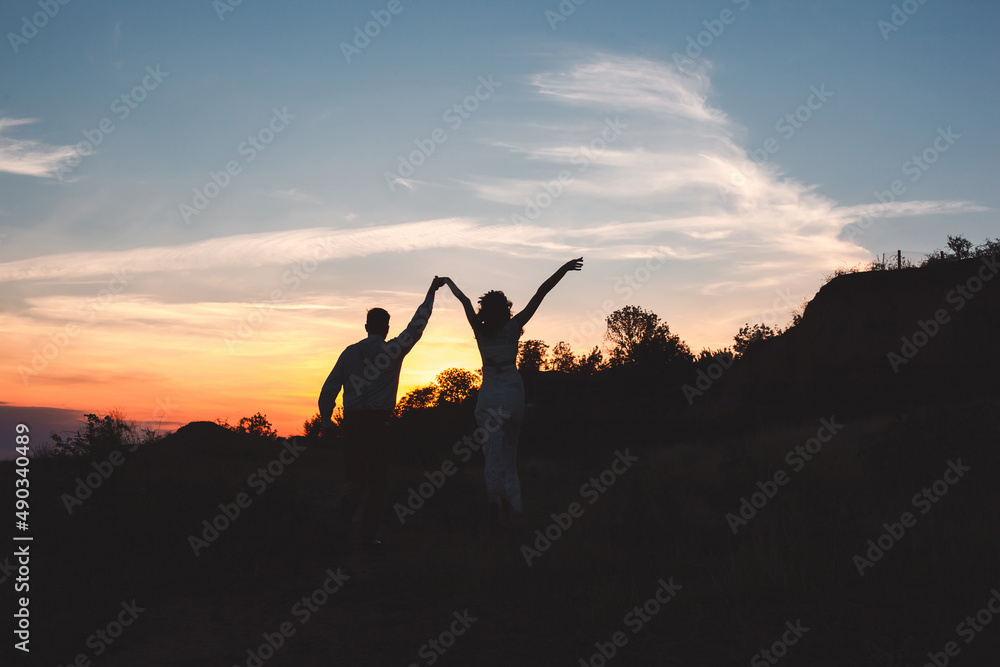 Loving  couple together outdoor in mountains over scenic sunset sky background.