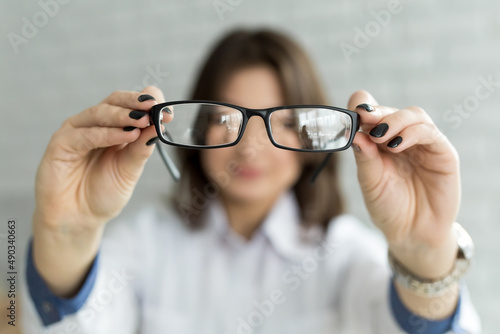 Close up female hands holding eyeglasses. Ophthalmology concept