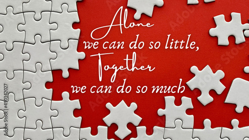 Bild auf Leinwand Top view of teamwork inspirational quote on red cover with jigsaw puzzle - Alone we can do so little, together we can do so much