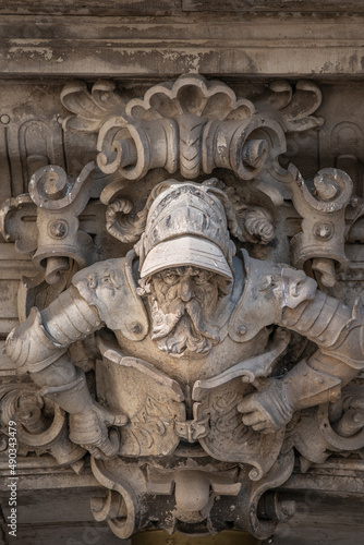 Ancient big statute of scary, fearful and heavy armed gatekeeper, medieval warrior with weapon in historical downtown of Dresden, Germany, details, closeup. Authentic European old architecture.