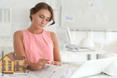 Beautiful female architect with laptop in modern office