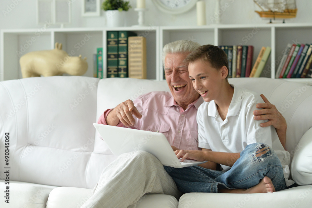 Boy and grandfather with a laptop at home Boy and grandfather with a laptop at home