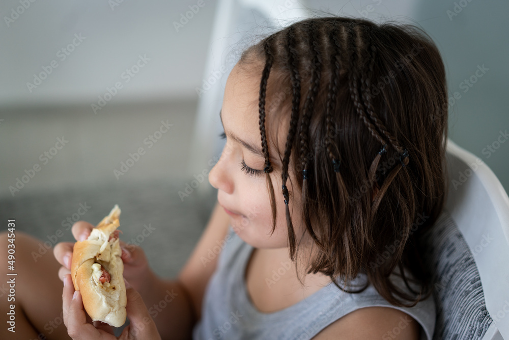 Little boy eating sandwich while sitting at desk in kitchen. High quality photo Little boy eating sandwich while sitting at desk in kitchen. High quality photo