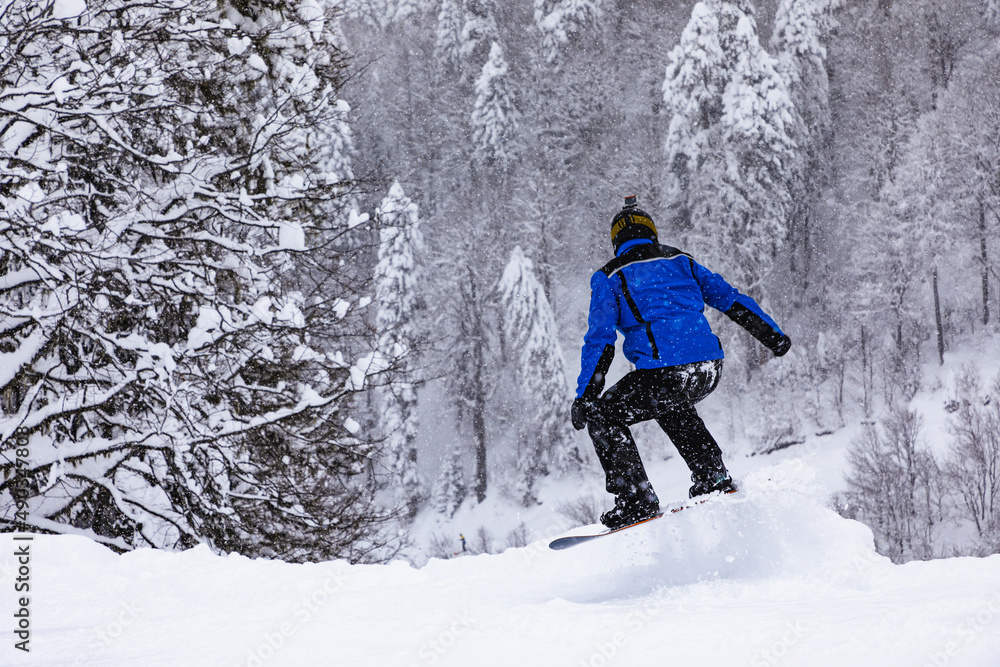 Anonymous man snowboarding in snowy forest Anonymous man snowboarding in snowy forest