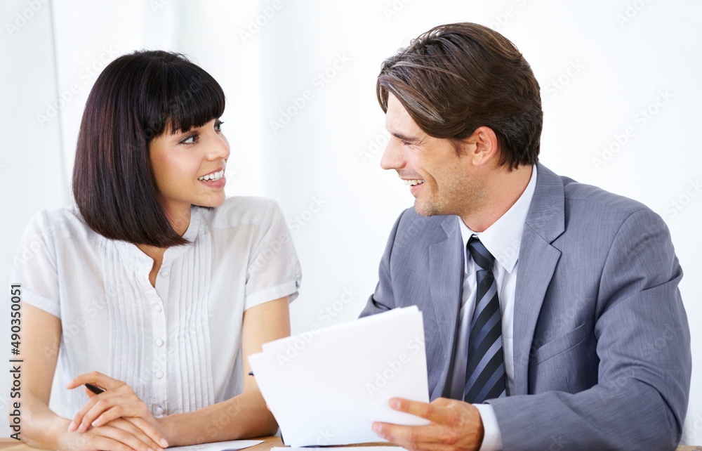 Putting their minds together to succeed. Two young executives enjoying a conversation in the office together. Putting their minds together to succeed. Two young executives enjoying a conversation in the office together.