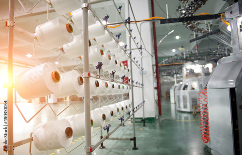 Textile industry - yarn spools on spinning machine in a textile factory photo