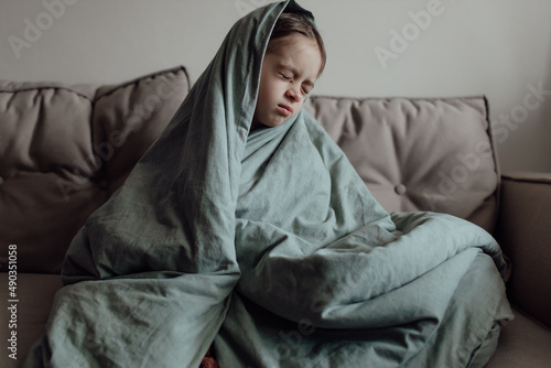 Stop war. Pray for Ukraine. we stand with Ukraine. Ukrainian frightened child under a blanket. The girl is afraid of the sounds of air raids and explosions. Poor child feeling sorrow and sadness.