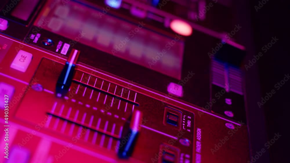 DJ hand presses button and moves fader on mixer console in disco club, closeup. Dj mixer controller desk in night club DJ hand presses button and moves fader on mixer console in disco club, closeup. Dj mixer controller desk in night club