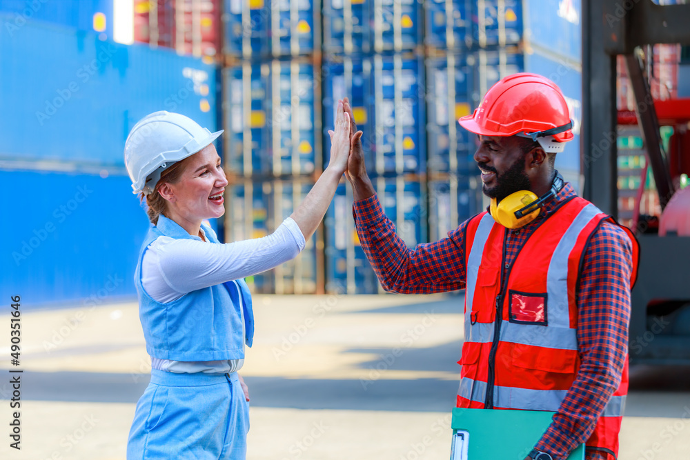 A team of African American men and Caucasian women wear helmets. Handshake to congratulate the successful event. A team of African American men and Caucasian women wear helmets. Handshake to congratulate the successful event.