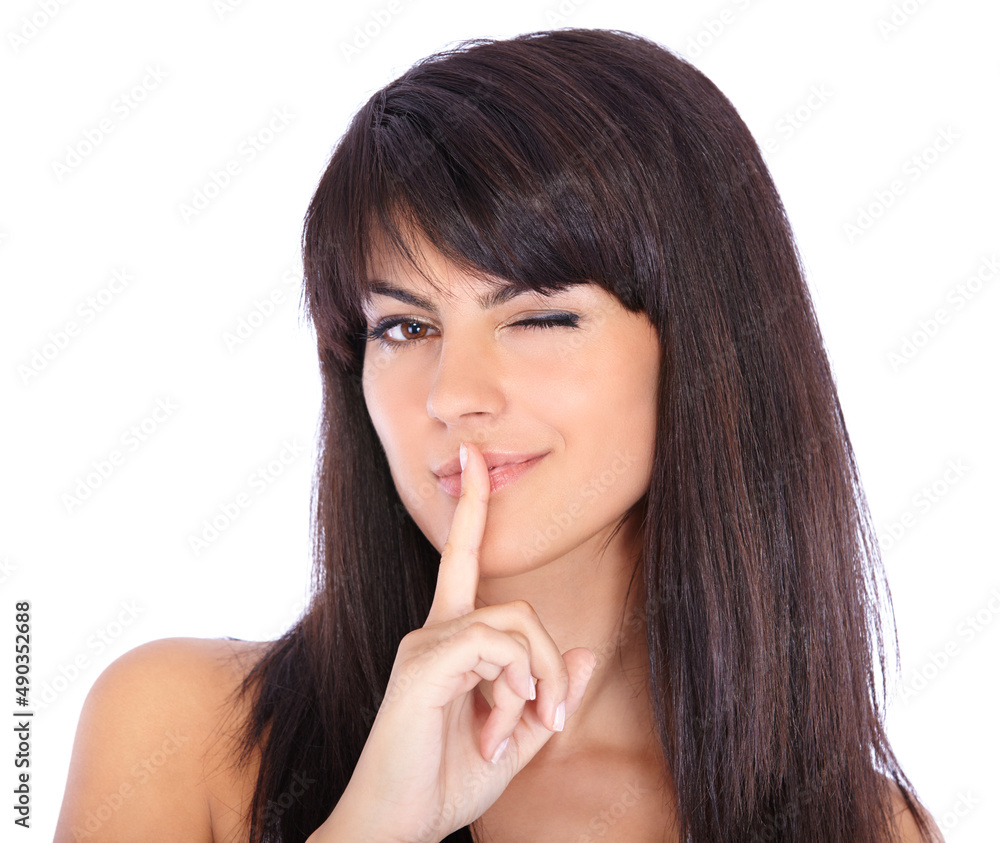 Just between us.... Closeup portrait of a beautiful young woman winking with her finger on her lips. Just between us.... Closeup portrait of a beautiful young woman winking with her finger on her lips.