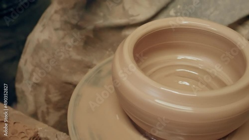 Apprentice learning clay pottery on ancient kick operated revolving wheel photo