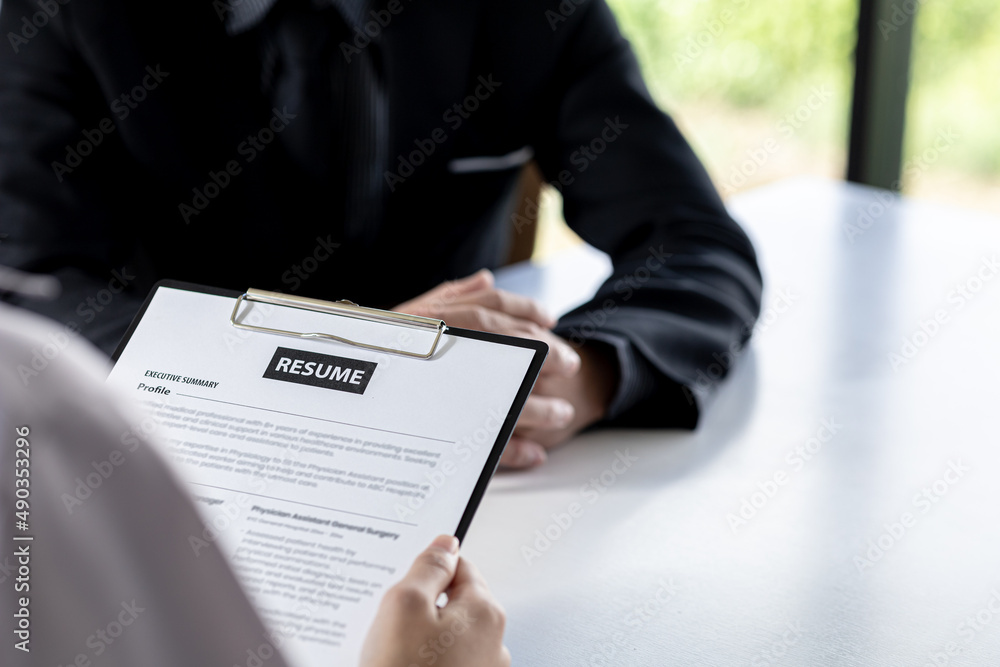 The job applicant is checking the resume with the Human Resources The job applicant is checking the resume with the Human Resources
