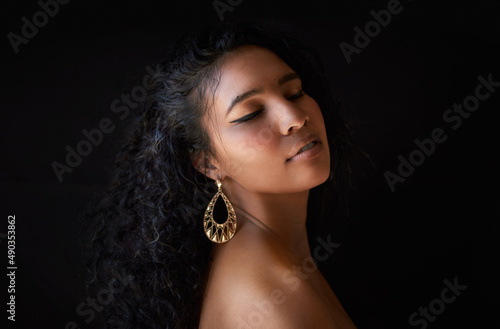 Nothing can dim the light which shines from within. Cropped shot of a beautiful young woman against a dark background.