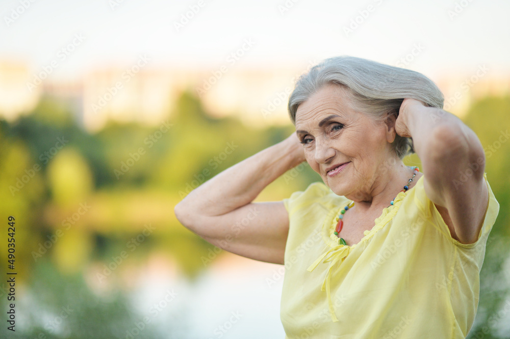 Portrait of happy senior beautiful woman by lake