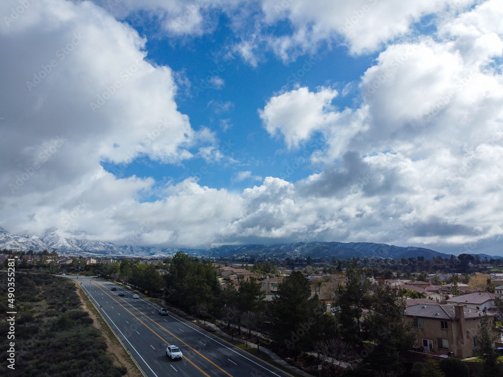 An Aerial UAV Drone Image of the Crafton Hills Area of Yucaipa, California, with Stacked Clouds During a Winter Storm and Snow on the Mountains An Aerial UAV Drone Image of the Crafton Hills Area of Yucaipa, California, with Stacked Clouds During a Winter Storm and Snow on the Mountains