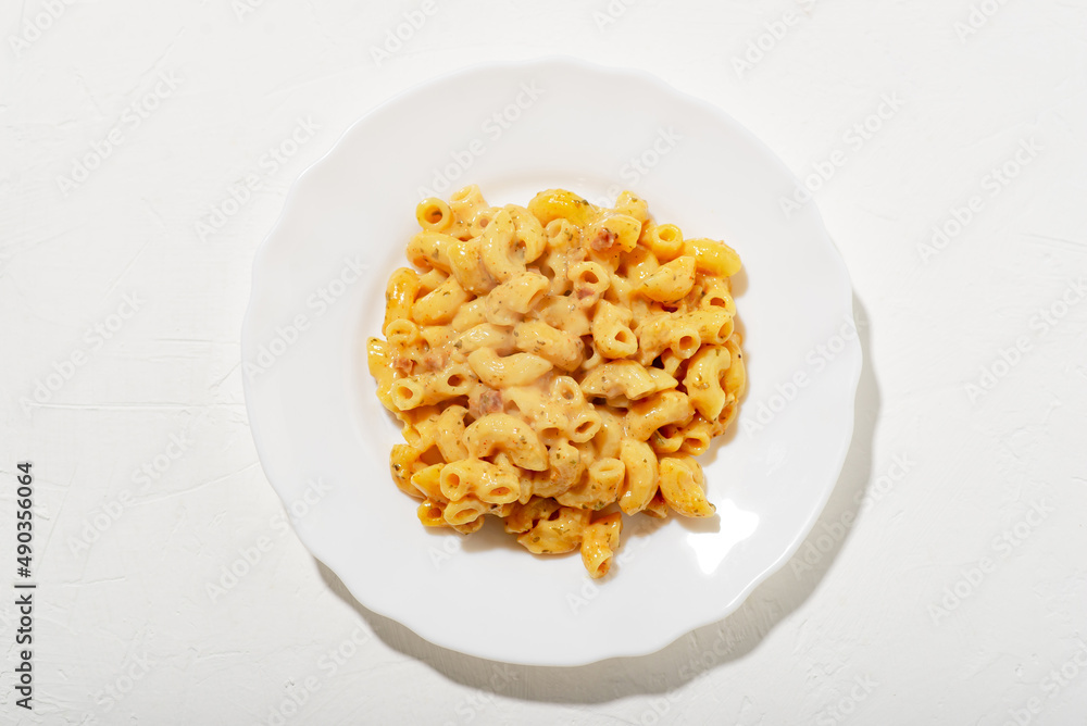 curly pasta with sauce on a white plate. Minimalism. White background. Pasta in cheese sauce. View from above. curly pasta with sauce on a white plate. Minimalism. White background. Pasta in cheese sauce. View from above.