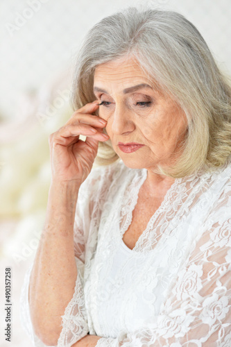 Portrait of thoughtful senior woman on bed
