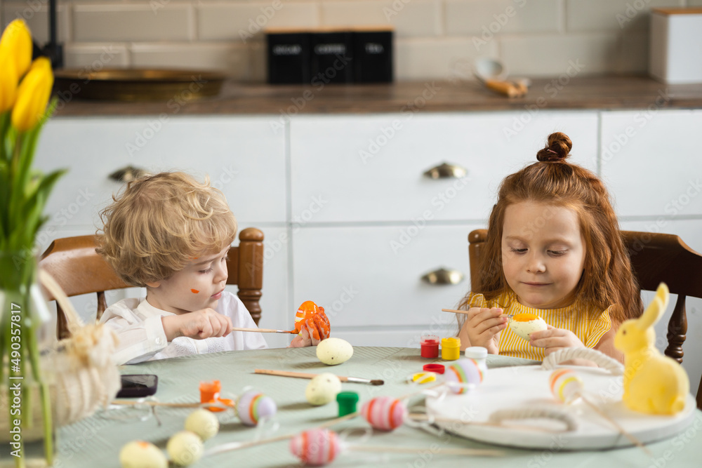 Boy and girl decorate Easter eggs